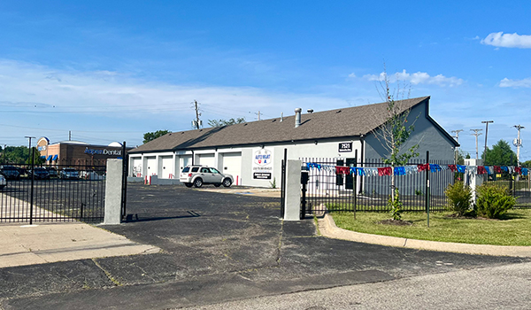 photo of 1 building with 6 bays and iron fence.
